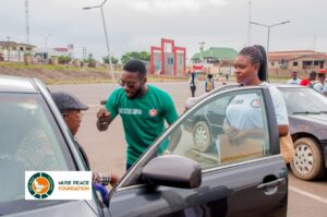 Muse volunteers advocating peace to a a motorist in Osogbo